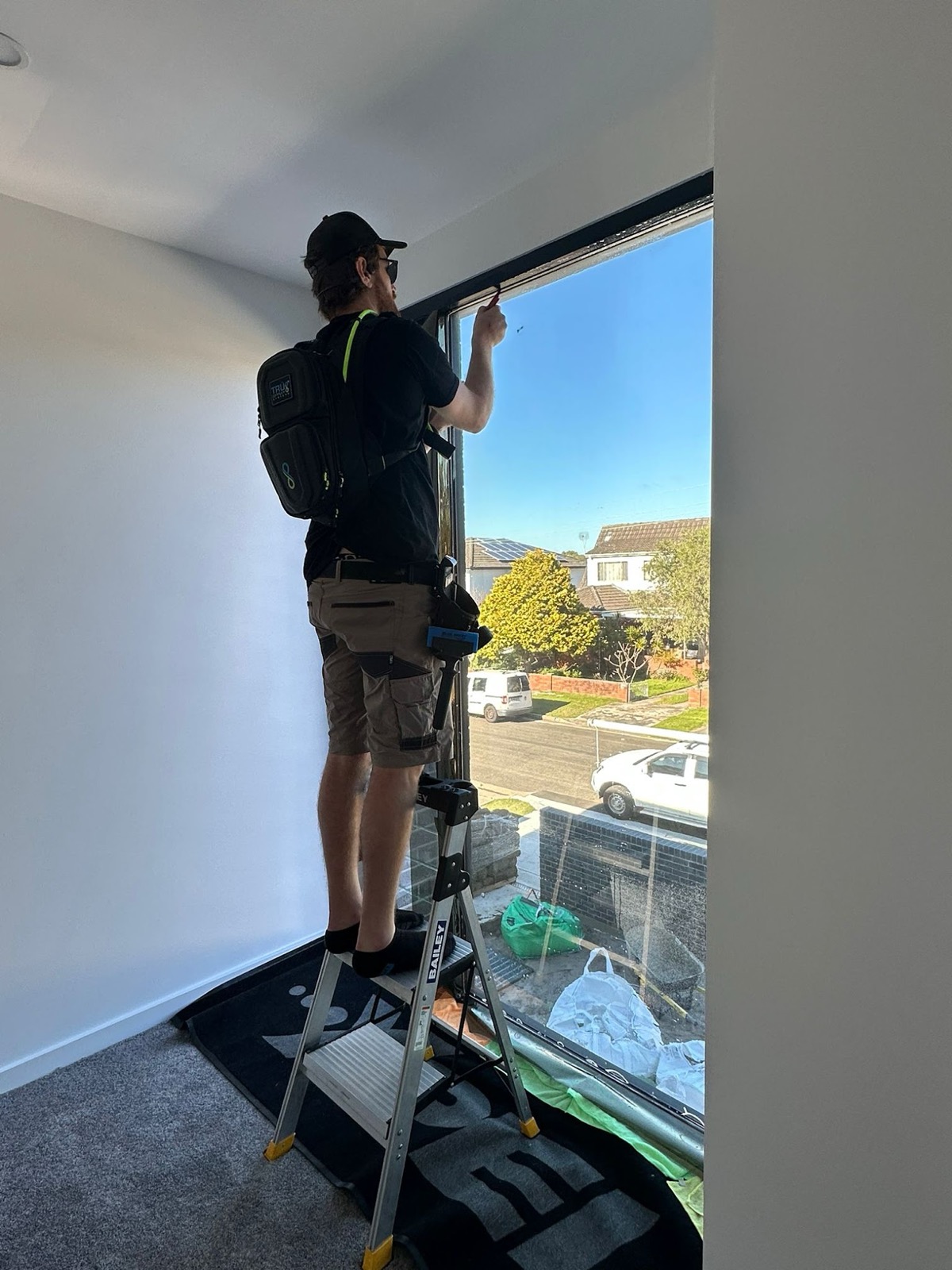 TintCo installer applying film to an upstairs window
